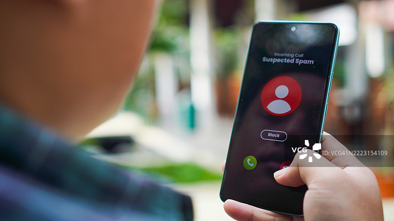 男子在智能手机上接到来自未知来电者的可疑电话并拒接该电话图片素材