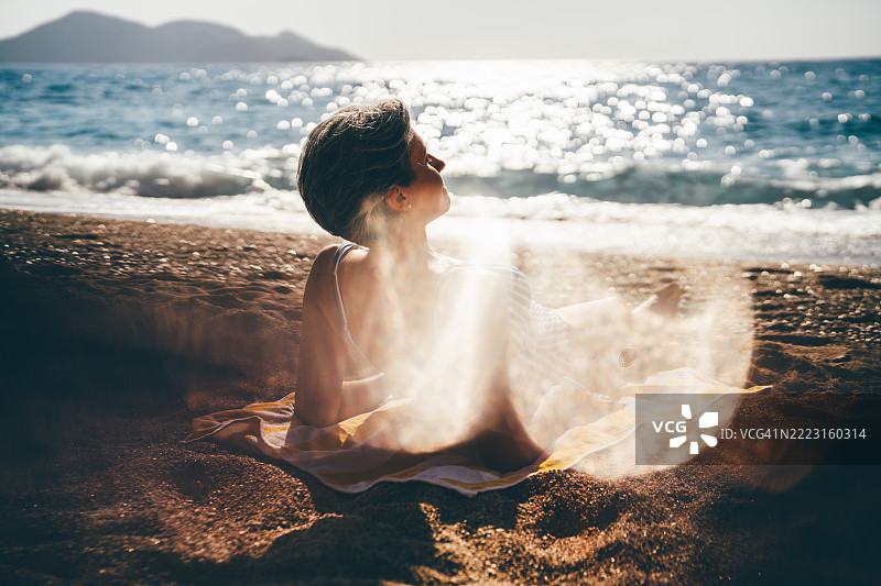 女人在海滩上晒太阳和放松。图片素材