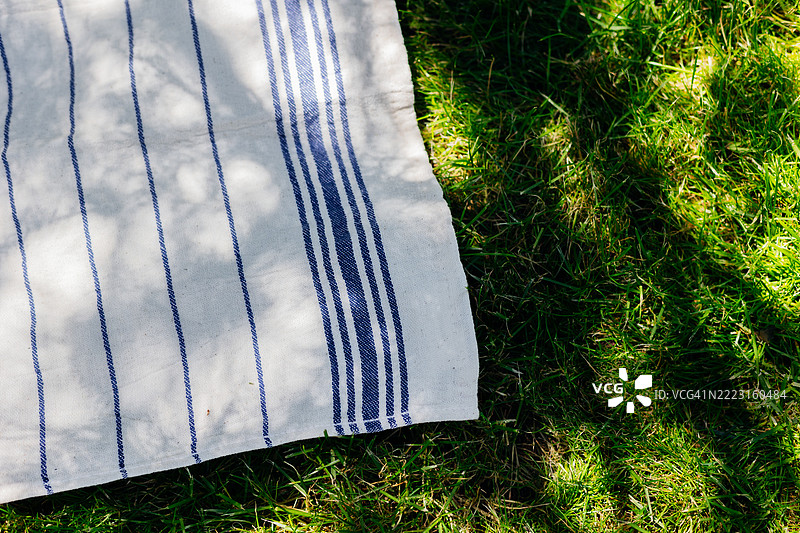 条纹布料与草地，带有自然阴影，阳光明媚的户外环境图片素材