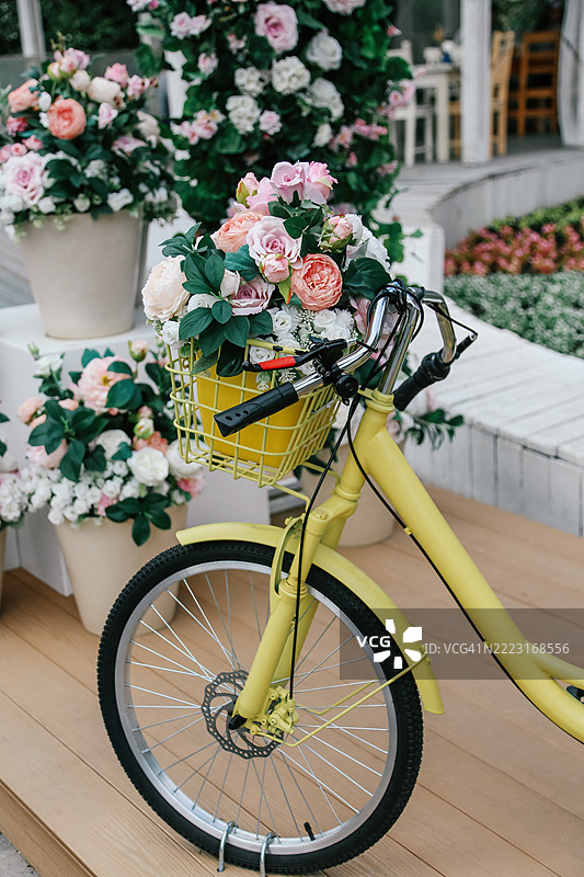 户外婚礼的节日装饰，黄色自行车篮子里装满鲜花图片素材