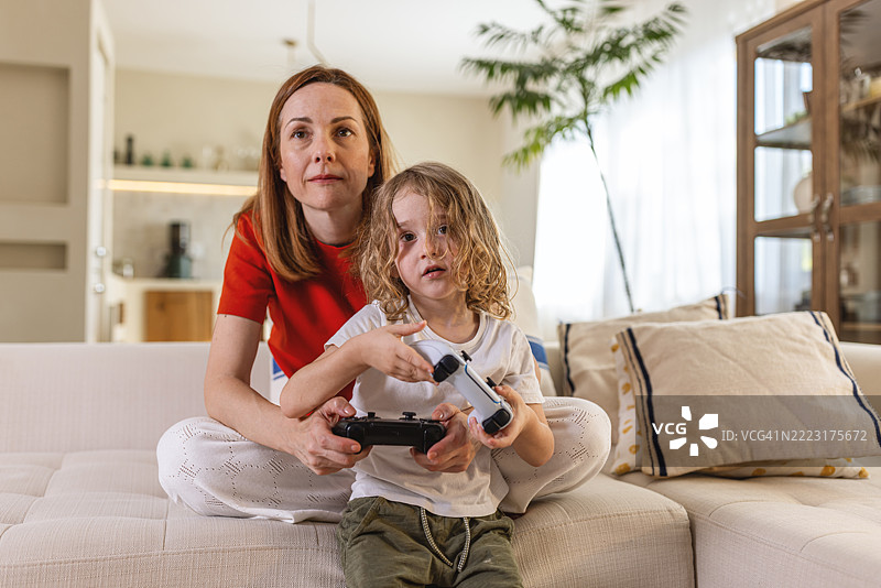 母亲和孩子在家里玩游戏图片素材