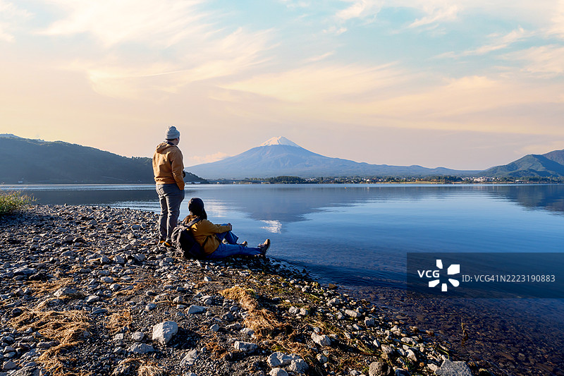 亚洲情侣在秋季的河口湖旅行，背景是富士山的美景。图片素材