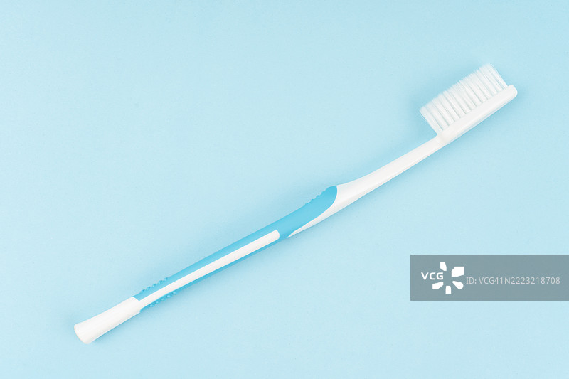 蓝色背景上的平铺白色牙刷。图片素材