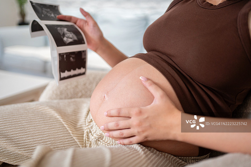 孕妇在家放松时手持超声波图像图片素材