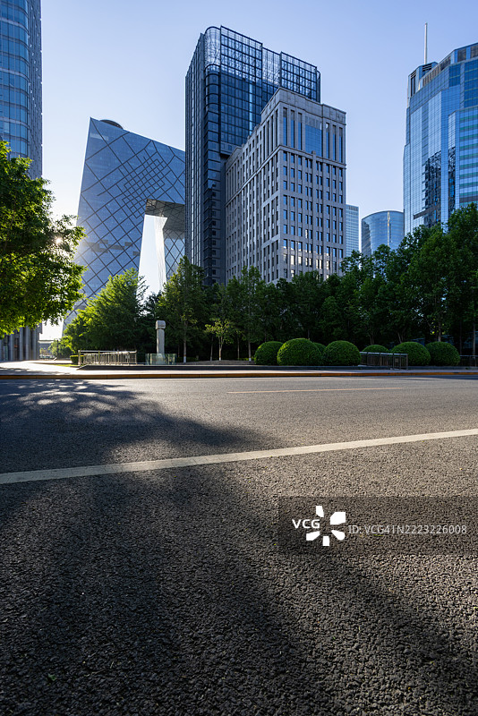 在城市摩天大楼下，清晨的阳光洒在开放的道路上，北京，中国。图片素材