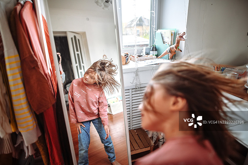 温暖的家庭氛围通过跳舞女孩的形象得以增强，镜子放大了她空中飞舞的秀发之美。图片素材
