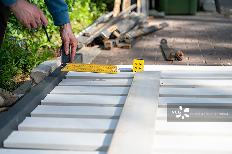 手工测量木栅栏施工的直角图片素材