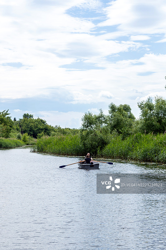 两个人在卡门卡河上划着一只木船图片素材