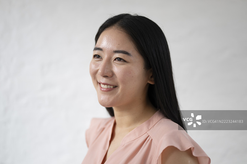 微笑的中年韩国女性侧身望向远方的肖像图片素材