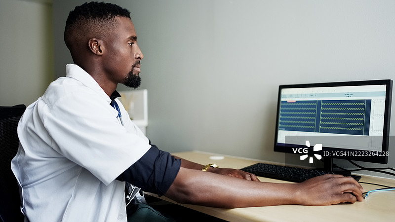 非洲医生在电脑屏幕上查看病人医疗记录图片素材