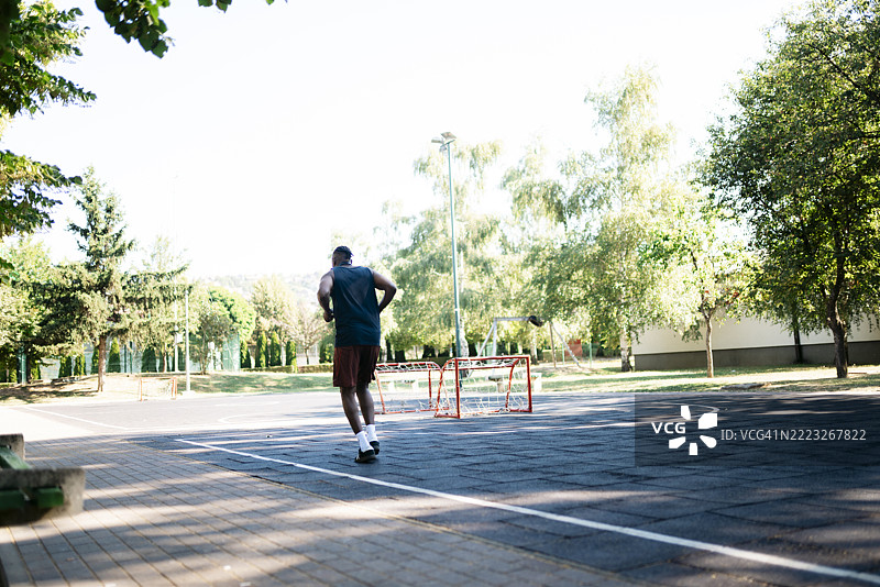 年轻男子在游乐场户外奔跑图片素材