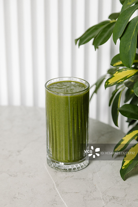 灰色桌子上的玻璃杯绿汁图片素材