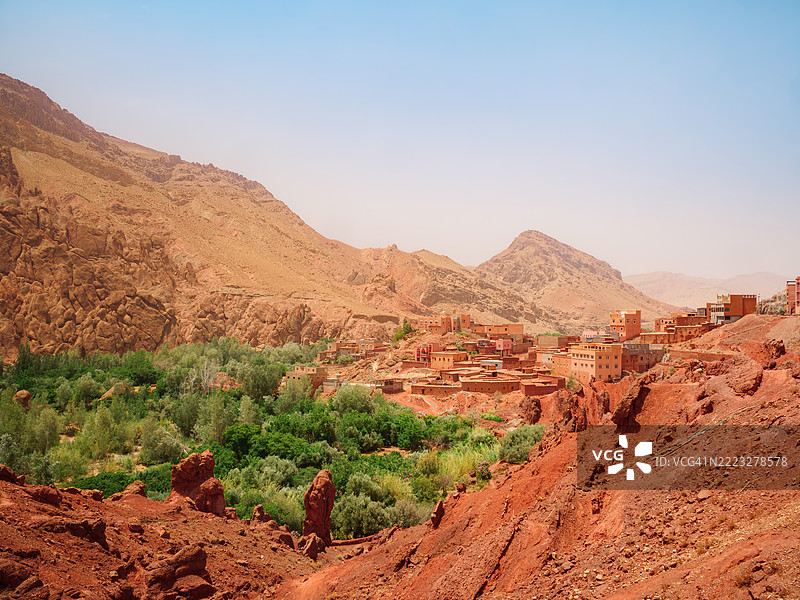 美丽的风景,色彩鲜艳,展示了达德斯山谷中的一个孤立村庄,村庄里有五彩斑斓的房屋,达德斯河床上满是树木和红色岩石,布马尔内·达德斯(Boumalne-Dadès) - 提内里夫省 - 德拉-塔菲拉勒 - 摩洛哥。图片素材