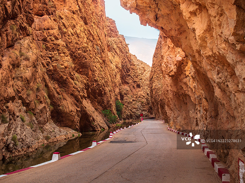在摩洛哥德拉-塔菲拉勒特省的布马尔内·达德斯，著名的达德斯峡谷底部，一条笔直的单车道空旷公路的广角视图。图片素材