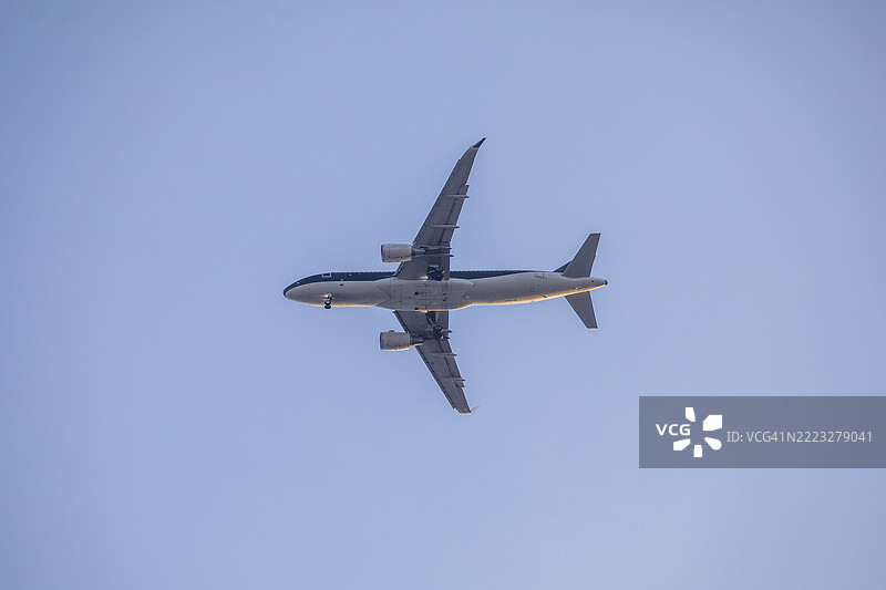 空中客车A320-214飞机在朦胧的天空中飞行图片素材