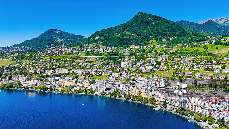 日内瓦湖畔蒙特勒的鸟瞰图，四周被瑞士阿尔卑斯山环绕，城市全景展示奢华酒店和住宅建筑，欧洲湖泊旅游目的地的旅行与旅游概念。图片素材