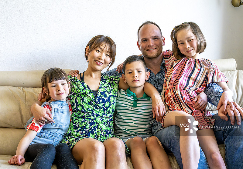 快乐的多种族家庭在家中。图片素材