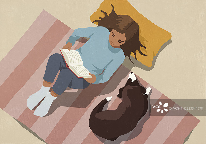 从上方俯瞰，女人在家中条纹地毯上放松，阅读书籍，旁边有一只狗。图片素材