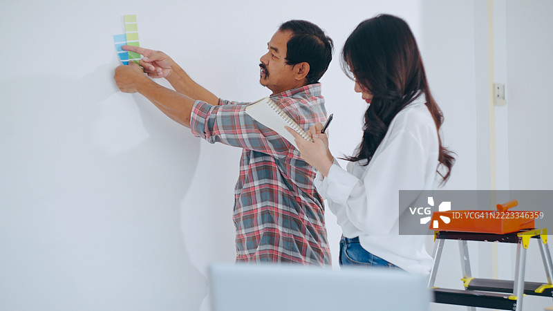 女人与正在公寓进行装修的工人达成协议。图片素材