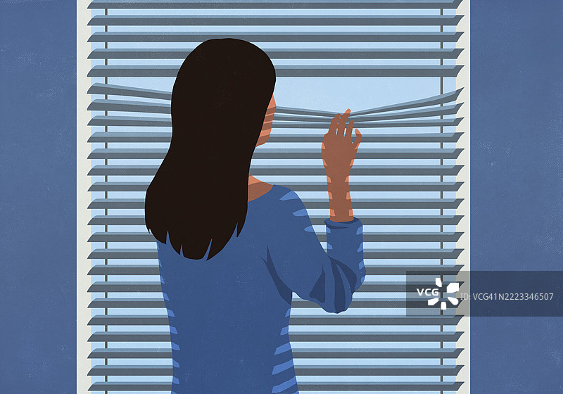 可疑的女人站在窗边，透过百叶窗窥视。图片素材