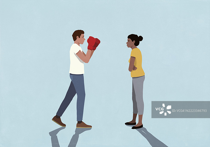 身穿拳击手套的男人与妻子面对面站在蓝色背景下，摆出战斗姿势。图片素材