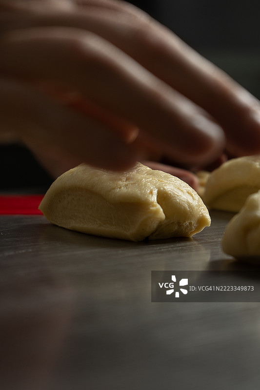 面包师正在用面团准备面包和蛋糕图片素材