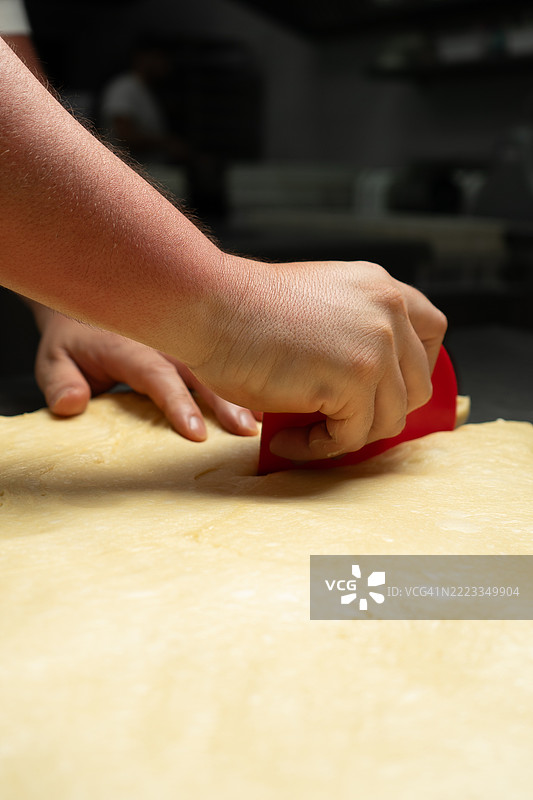 面包师正在用面团准备面包和蛋糕图片素材