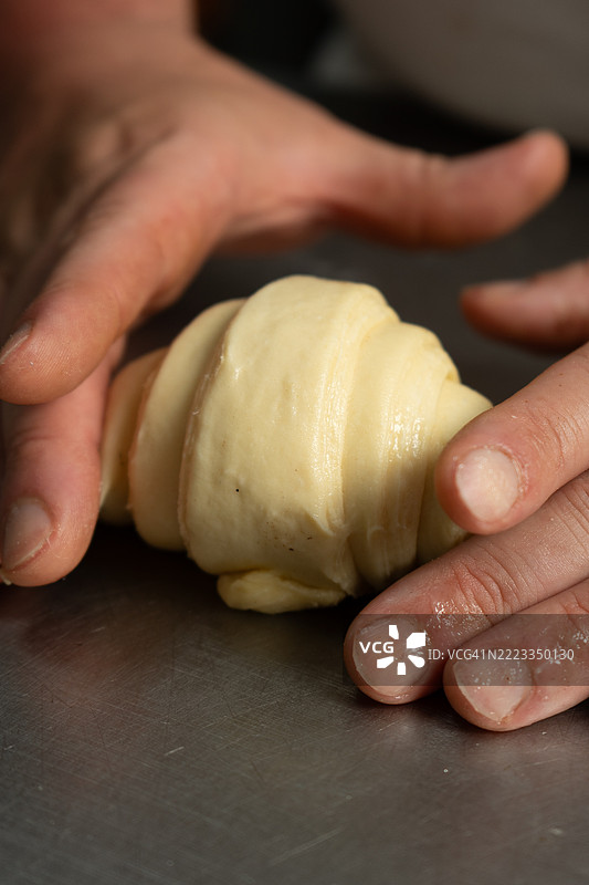 面包师正在用面团准备面包和蛋糕图片素材