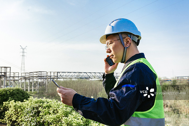 亚洲工程师在户外使用平板电脑和手机工作图片素材