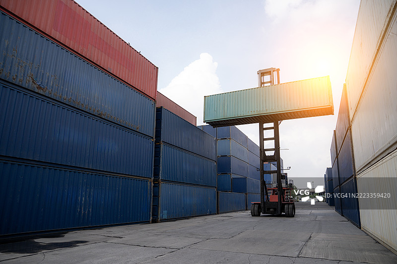 叉车在港口仓库移动集装箱，国际运输与物流概念图片素材