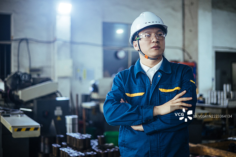 工厂车间内站着的男性技术员肖像。图片素材