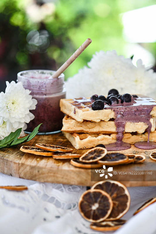 新鲜制作的华夫饼，搭配有机果酱和蓝莓，精美地摆放在木板上。图片素材