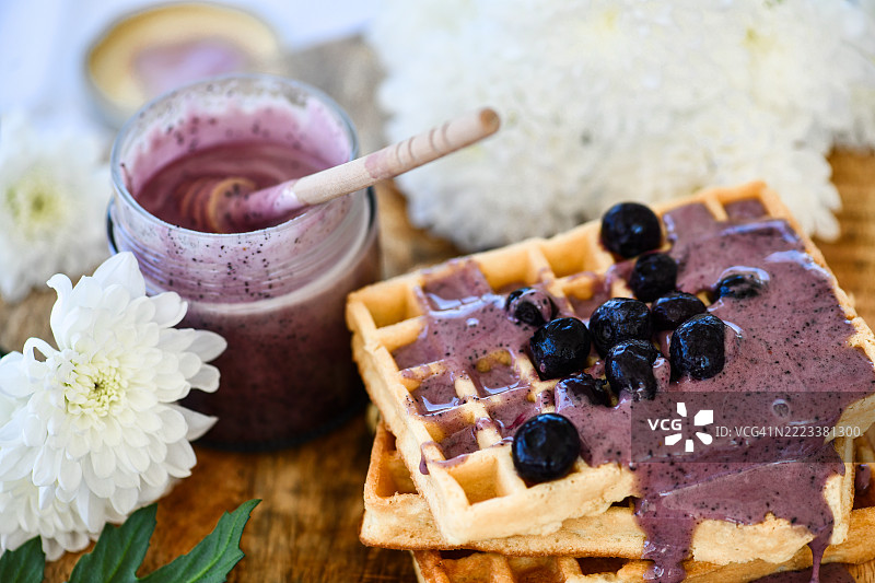乡村风格的早餐摆设，包含华夫饼、蓝莓果酱和蓝莓，放在木质切菜板上图片素材