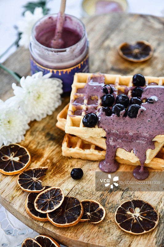 自制华夫饼美味，搭配甜美的蓝莓酱和饱满的浆果，摆放在乡村风格的木板上图片素材
