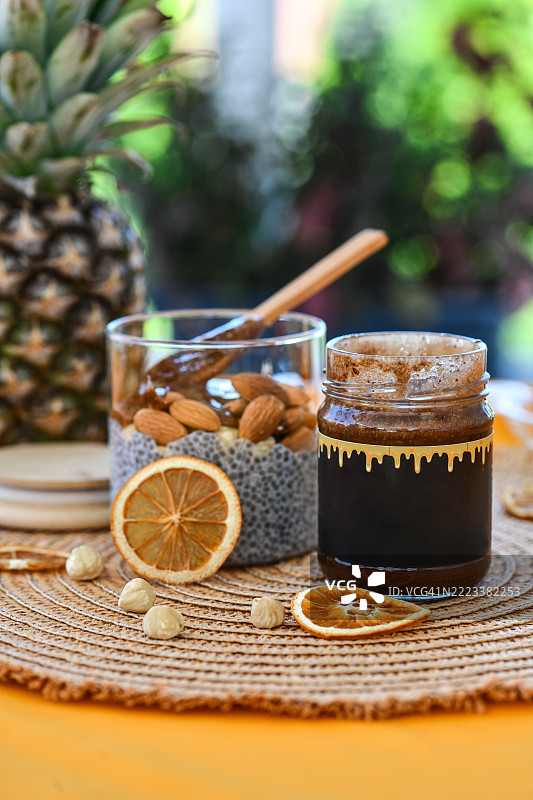 营养丰富的奇亚籽布丁，装在罐子里，配有顺滑的巧克力酱和坚果图片素材