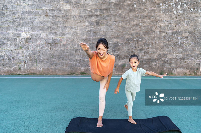孕妈妈在户外与女儿一起练习瑜伽图片素材