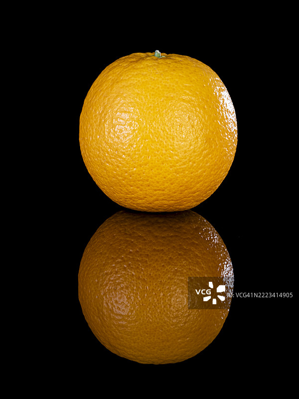 黑色背景上反射的橙色水果特写图片素材