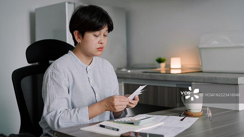 亚洲女性在家计算开支图片素材