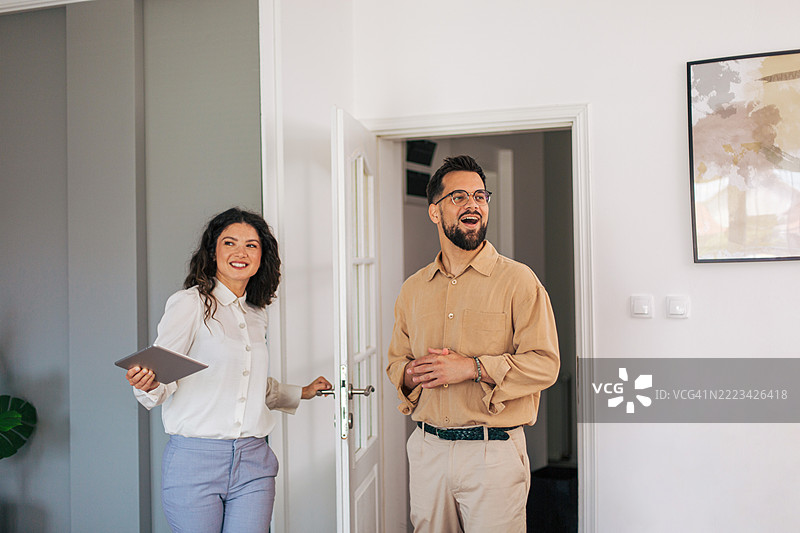 房地产经纪人向快乐的客户展示公寓图片素材