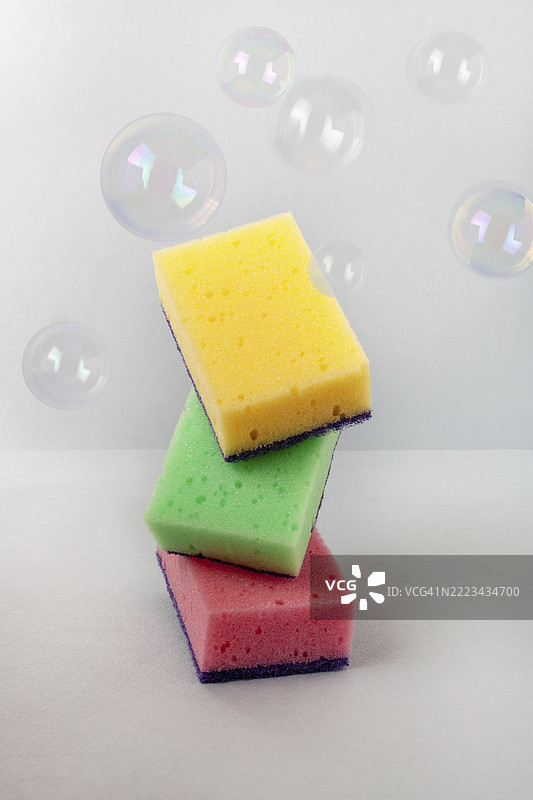 洗涤用彩色海绵的平衡与肥皂泡泡图片素材