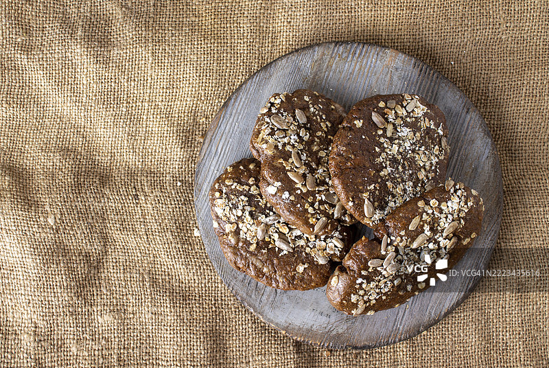 圆木板上的种子黑麦饼，放在画布上图片素材