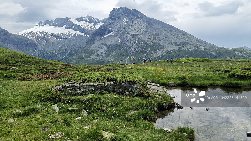 在托丘霍恩山的徒步旅行者,背景是布雷特霍恩山、莱昂山和赫布施霍恩山,靠近辛普隆口。图片素材