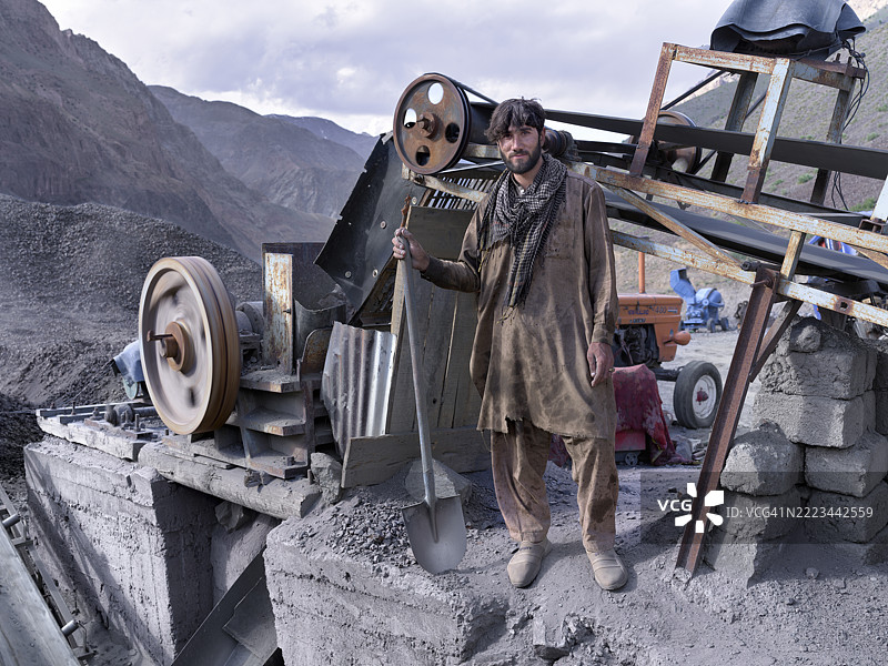阿富汗矿工在山谷的石料破碎厂手持铲子图片素材