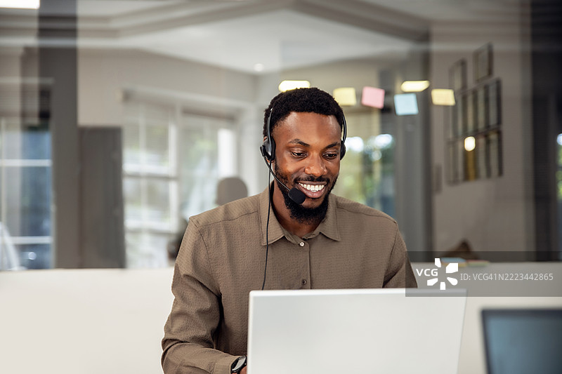 戴着耳机和使用笔记本电脑的销售人员和顾问，提供支持或建议图片素材