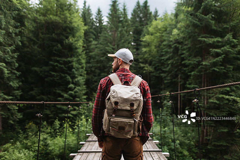 户外探险者在森林中的吊桥上旅行图片素材