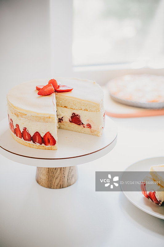 切片草莓层蛋糕，手在柔和的灯光下取一块图片素材