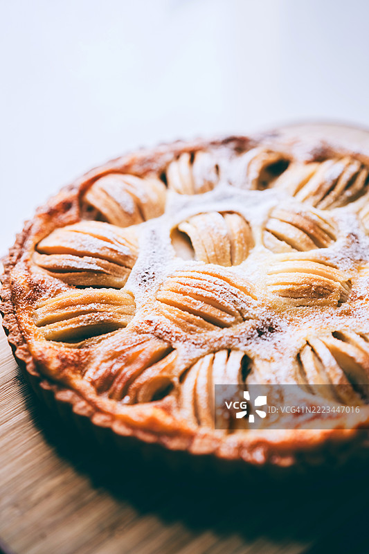 在温暖的自然厨房光线下烘焙撒有糖粉的艺术派图片素材