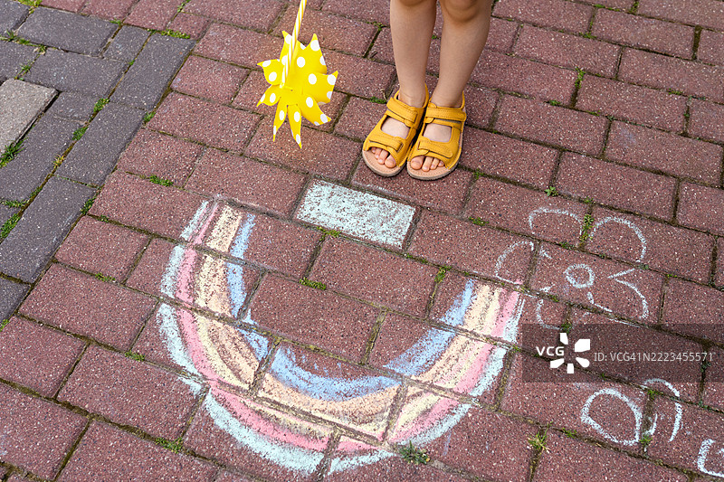 孩子在路面上创作五彩缤纷的粉笔艺术图片素材