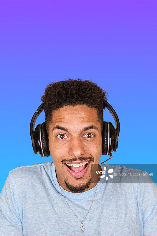 年轻男子戴着耳机享受在线游戏图片素材