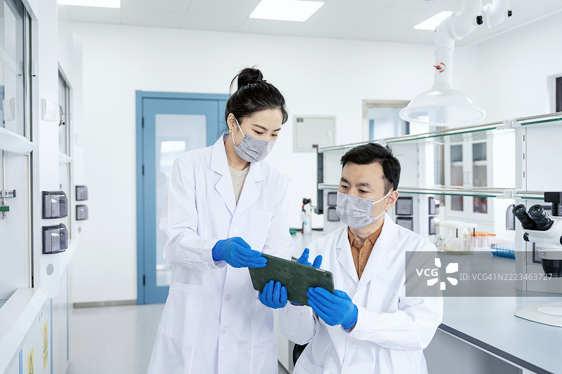 亚洲科学家在实验室讨论实验结果。科学实验室中的研究与开发概念。图片素材